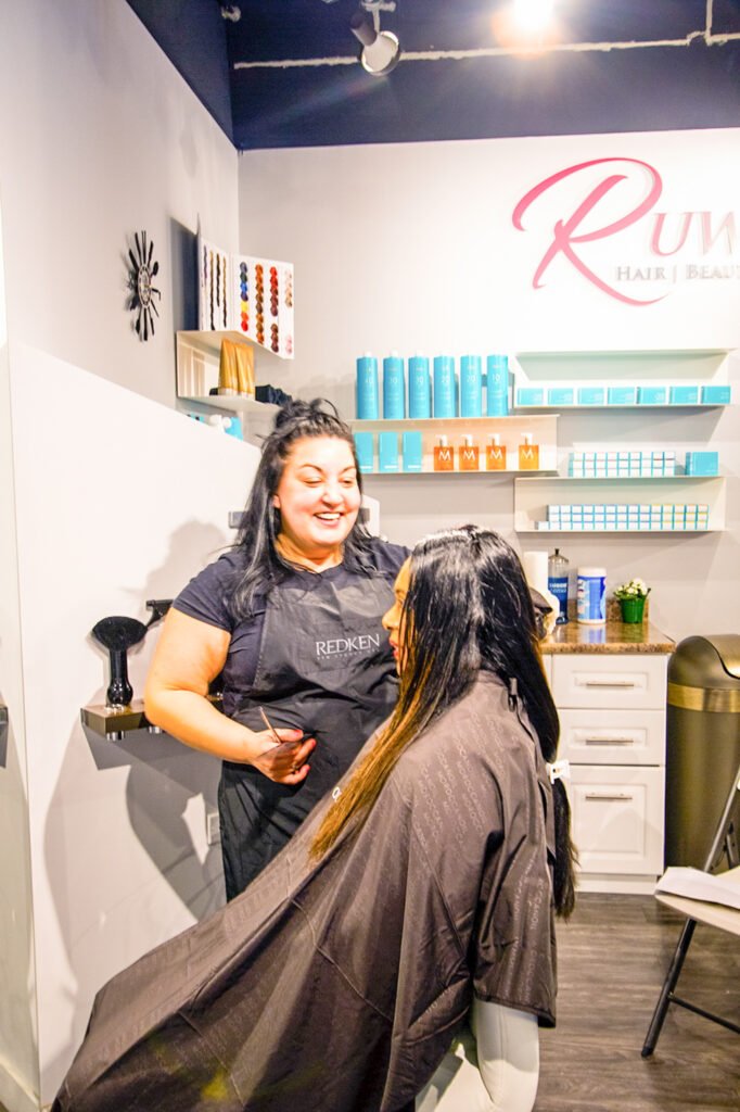  Hair stylist providing service to a client at Ruwis' Hair, Beauty & Nails in Winnipeg